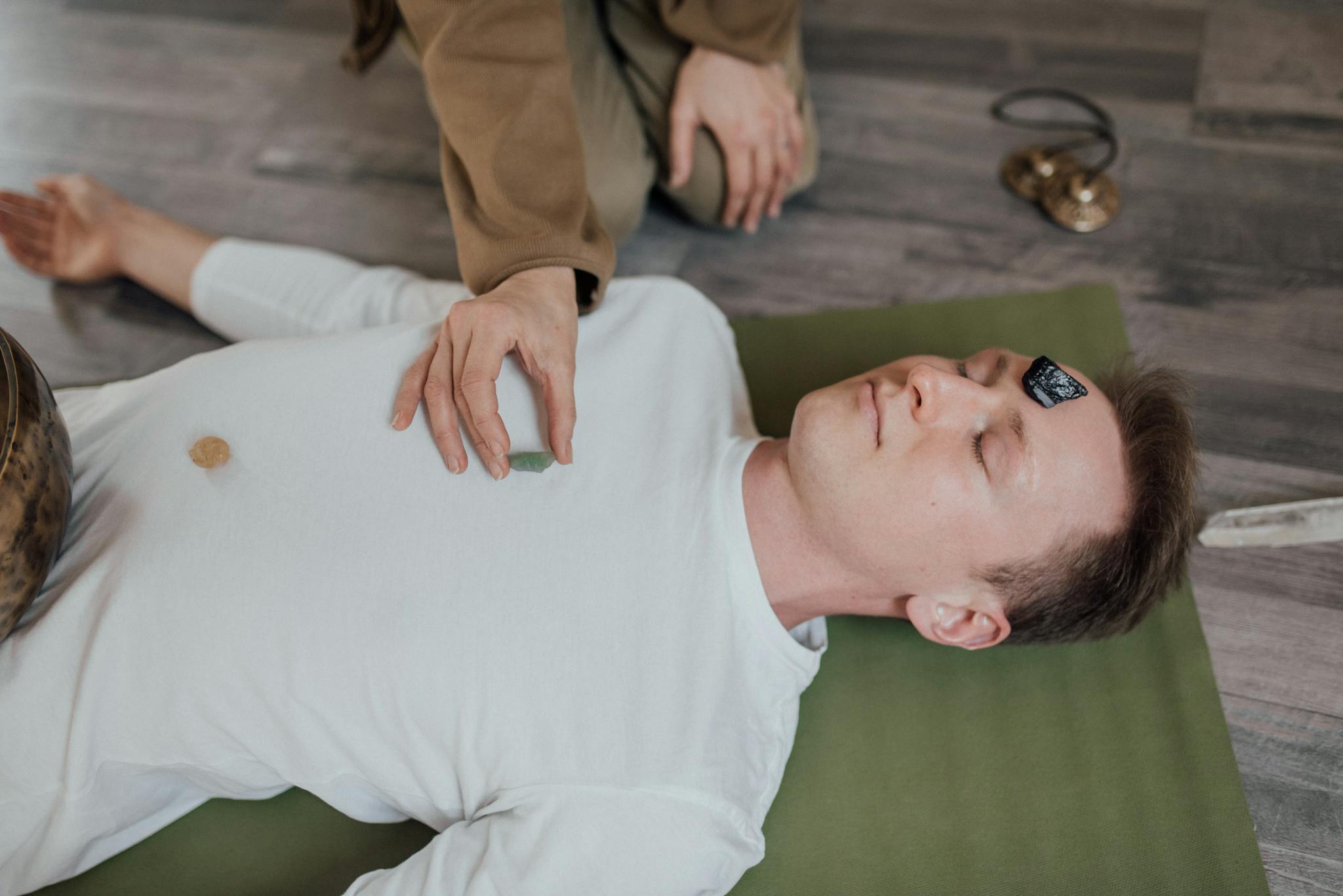 a man lies peacefully with crystals during
